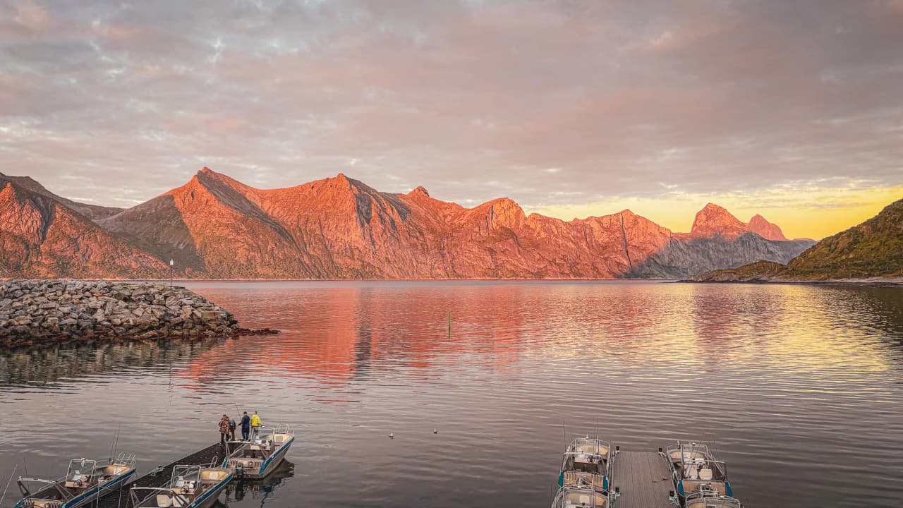 Zonsondergang over de majestueuze Senja bergen, magische reflecties op het kalme water.
