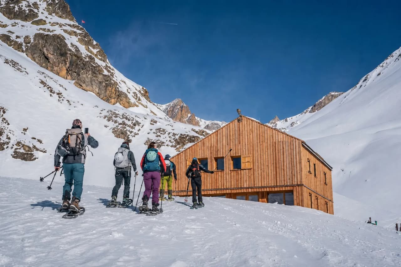 A group of snowshoe hikers heading for a cosy Mountain hut in the Hautes-Alpes.