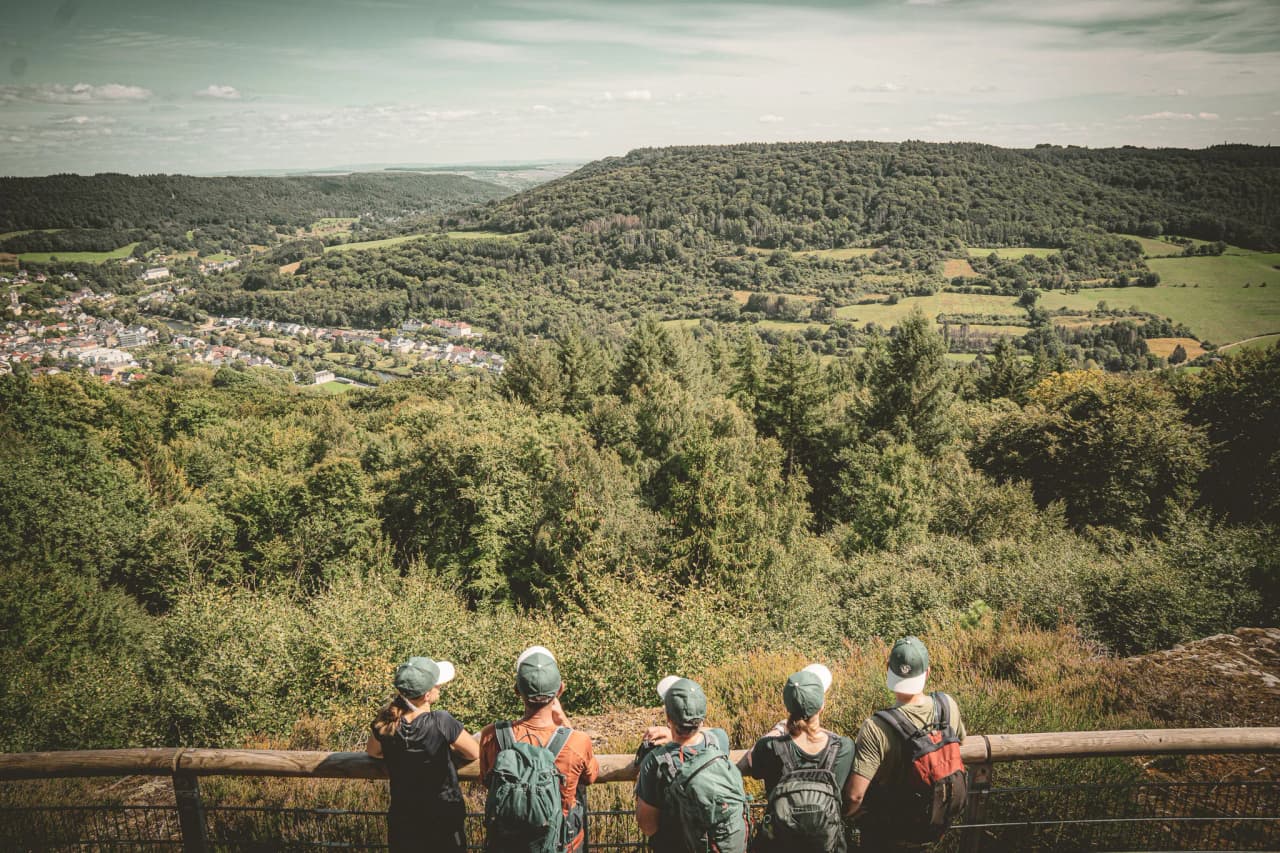 A group of walkers admiring the green landscape of Luxembourg's Little Switzerland.