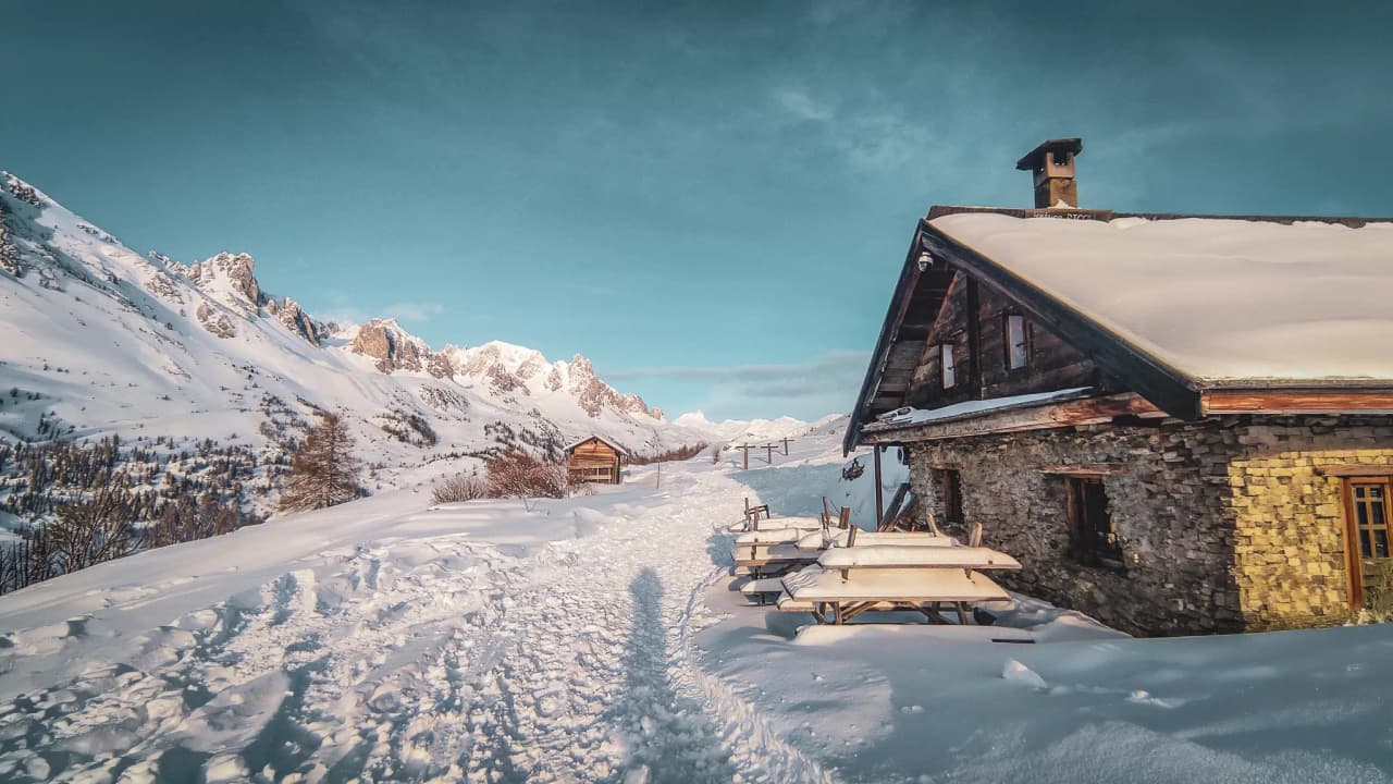 Refuge chaleureux entouré de montagnes enneigées, parfait pour une aventure hivernale.
