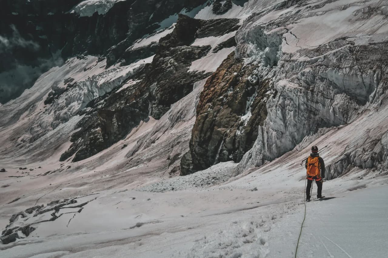 Alpiniste contemplant les glaciers majestueux du Mont Rose, prêt pour l'aventure.