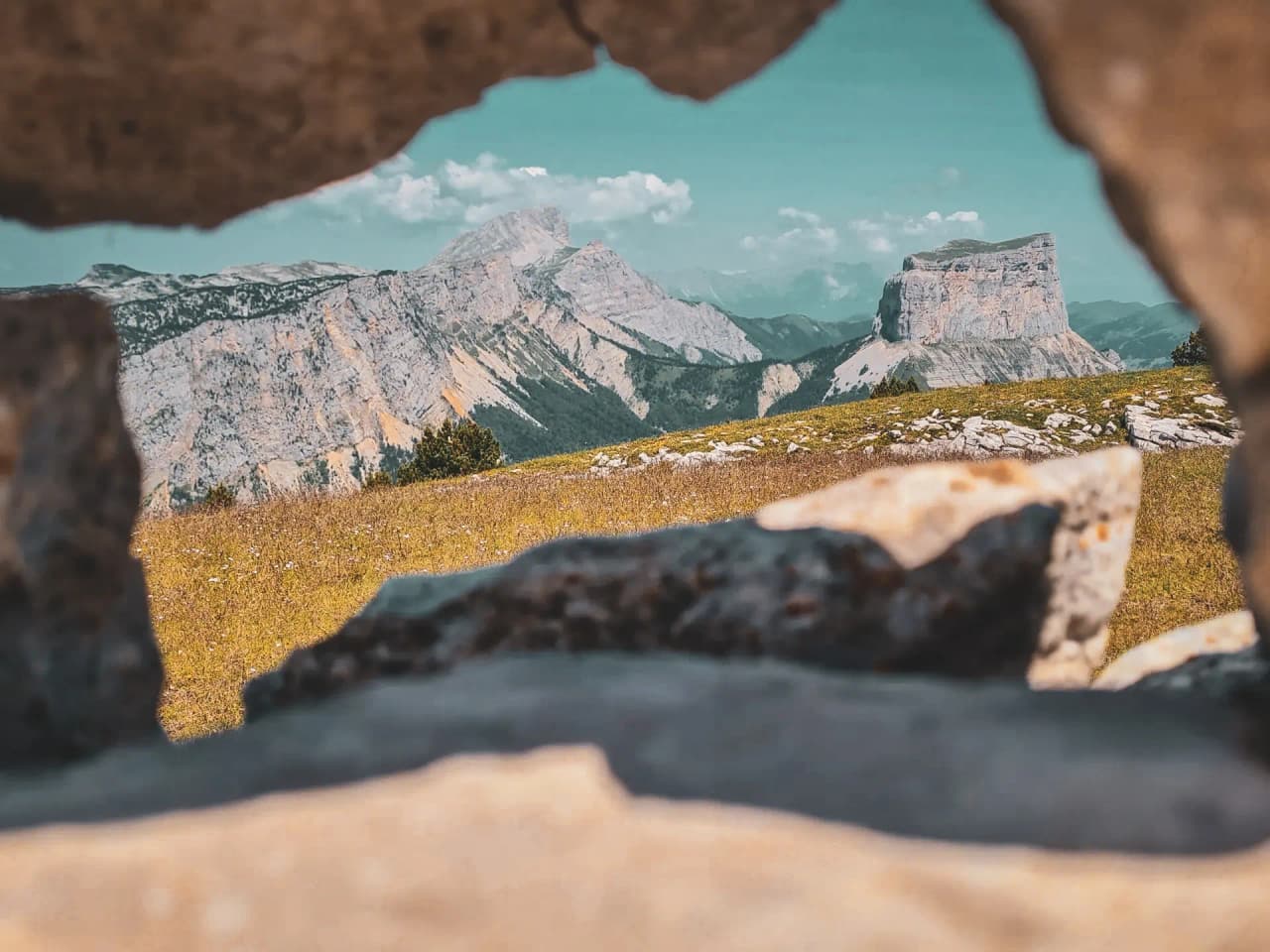 A panoramic view of the Vercors High Plateaux through a rocky opening, an invitation to adventure.