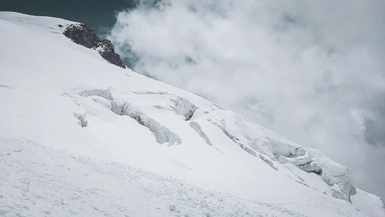 Montagne majestueuse recouverte de neige, ciel nuageux, invitation à l'aventure alpine.
