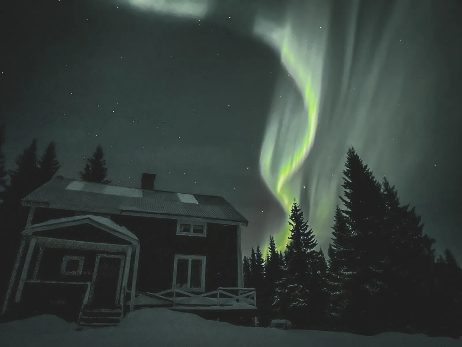 Aurores boréales illuminant le ciel au-dessus d'une maison enneigée en Laponie.