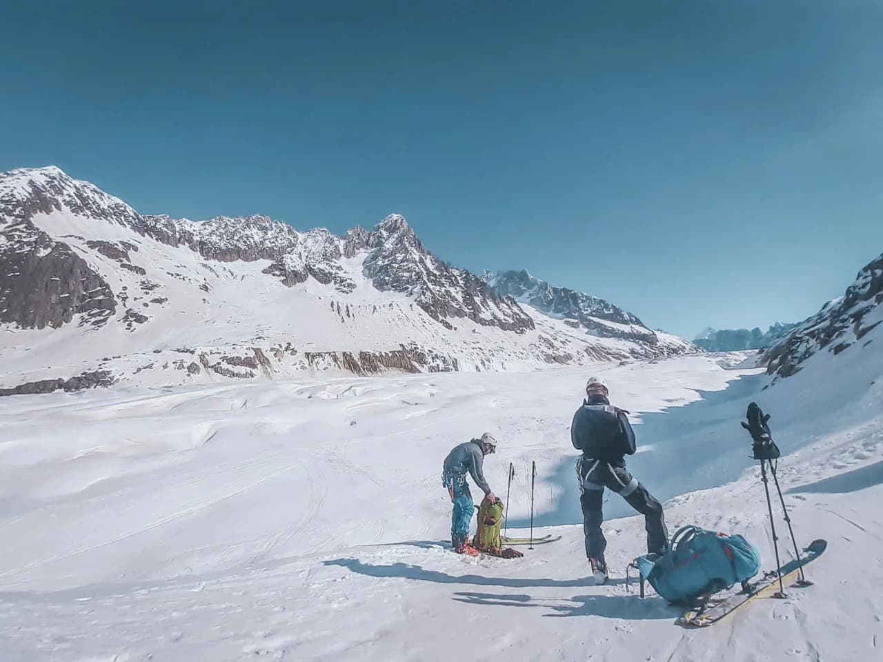 Groupe de skieurs devant des glaciers majestueux, ciel bleu, esprit d'aventure au Mont Blanc.