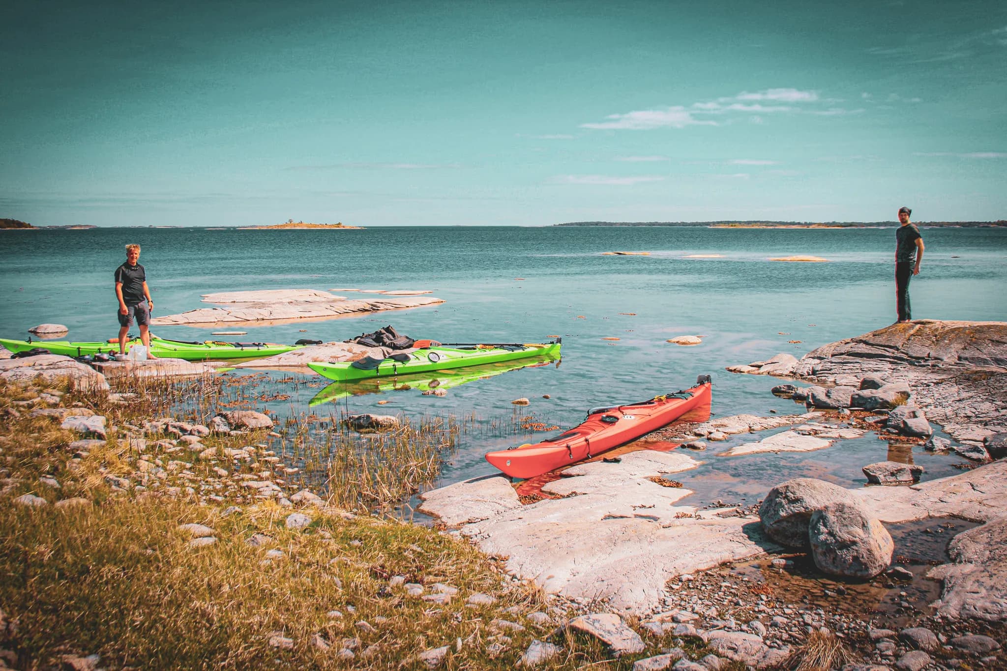 Two green kayaks and a red one, close to the calm waters of the Stockholm islands, invite you to escape.