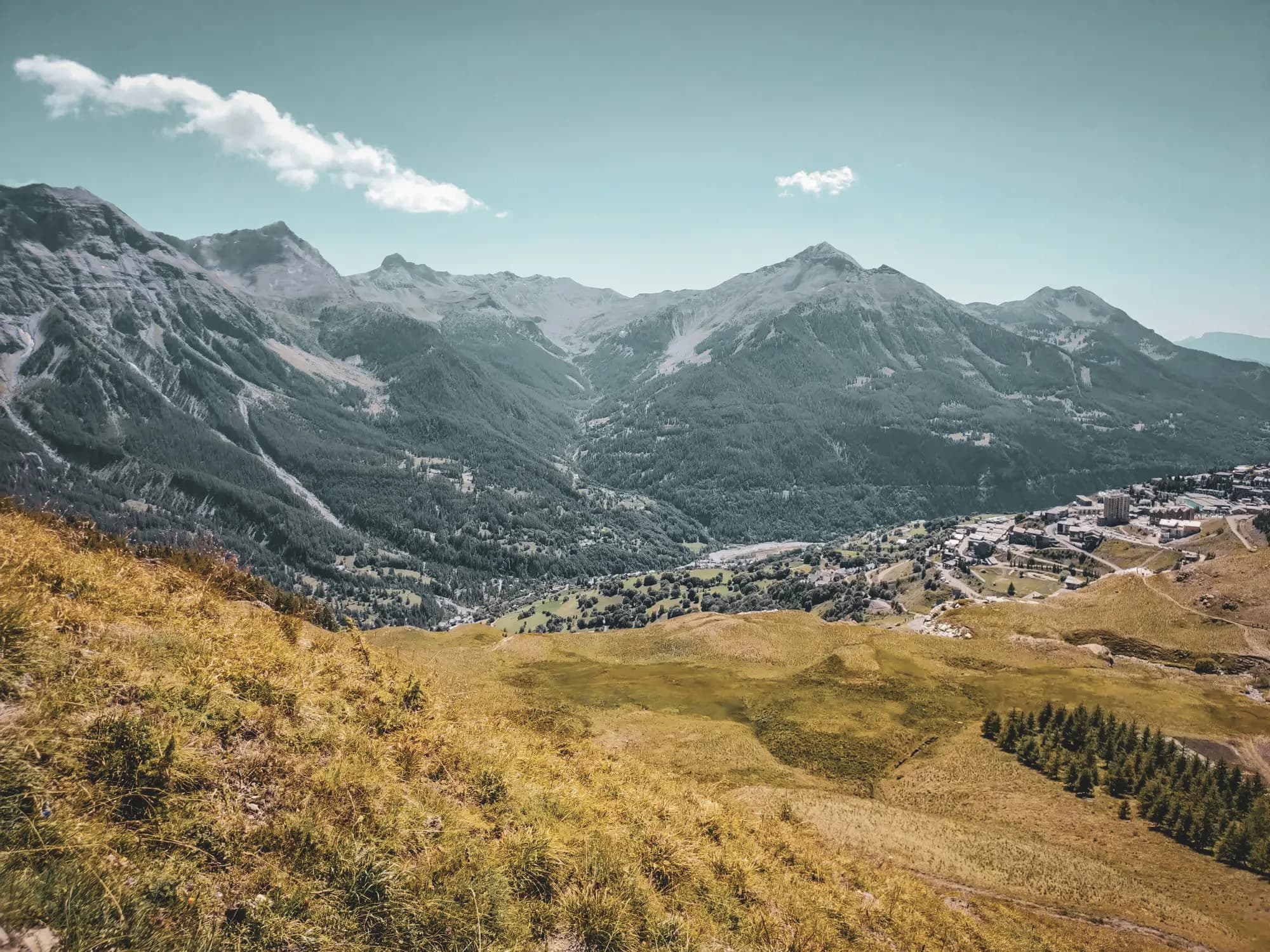 Spectacular Alpine scenery with lush green mountains under a clear blue sky.