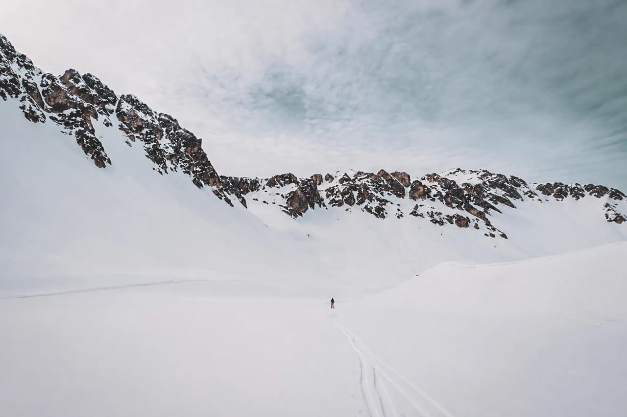 Een uitgestrekt besneeuwd landschap met majestueuze bergtoppen, dat uitnodigt tot bergavonturen.