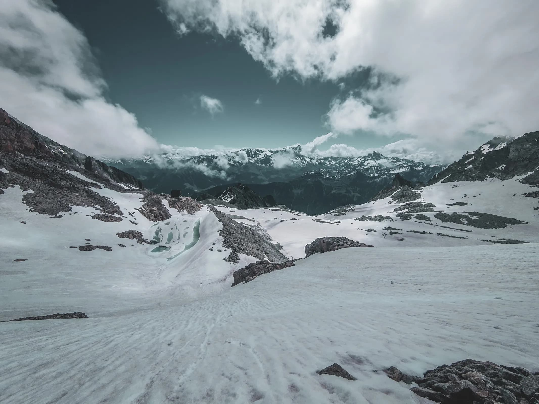 Majestic glacial scenery with mountains, eternal snow and alpine peaks under a cloudy sky.