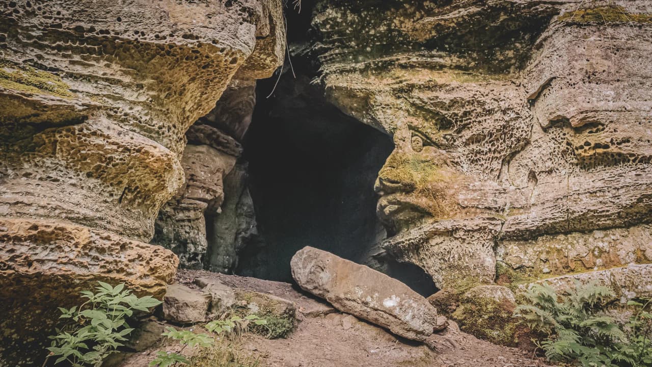 Een mystieke ingang van een grot in het hart van de kliffen van het Mullerthal, die uitnodigt tot avontuur.