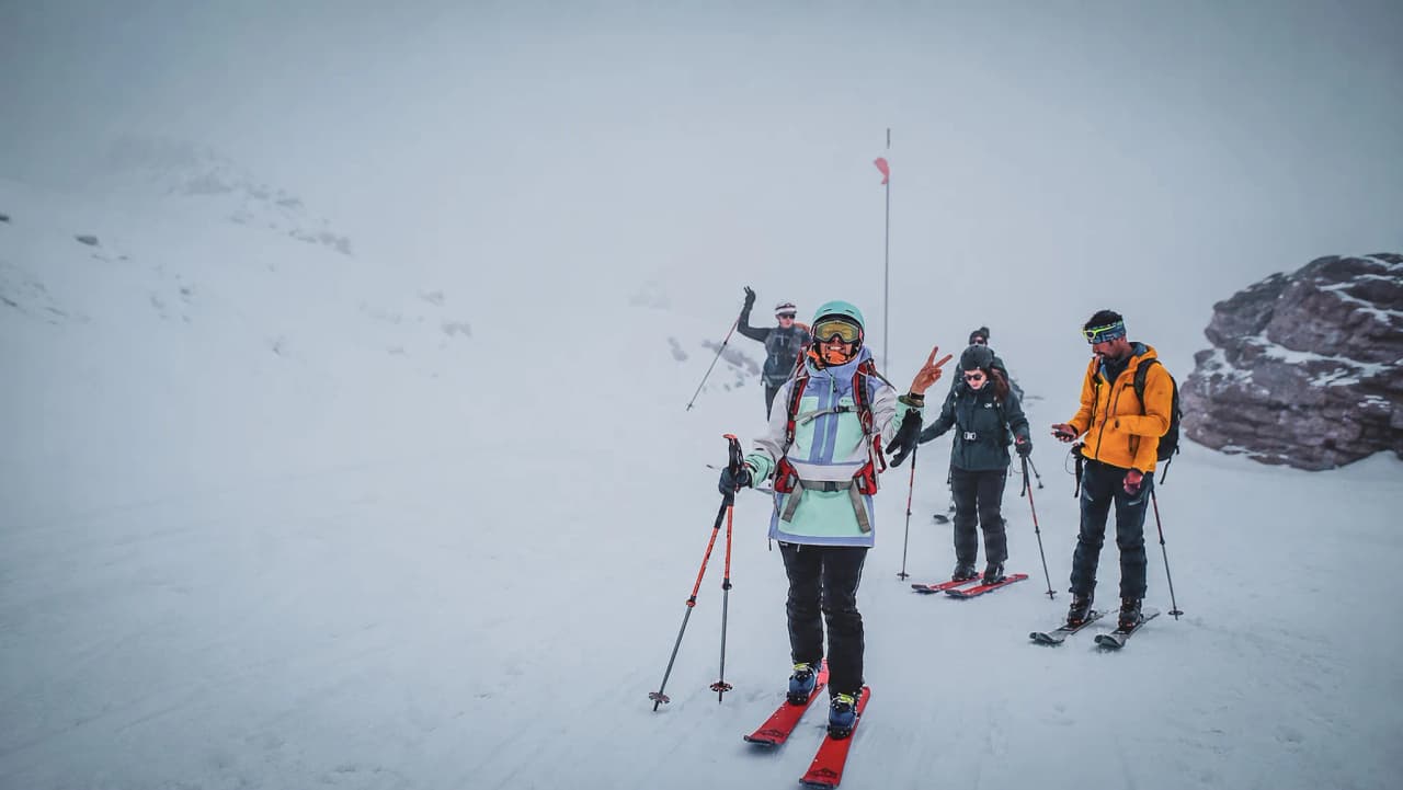 A group of adventurers on ski touring, smiling brightly in the snow-covered Alps.