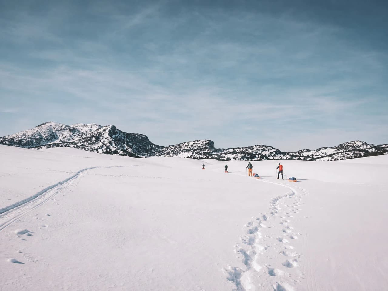 Sneeuwschoentochten door een besneeuwd landschap in de Vercors, met bergen op de achtergrond.