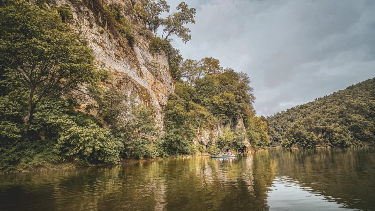 Bord de la Dordogne, falaises verdoyantes et canoës, invitation à l'aventure et à la découverte.