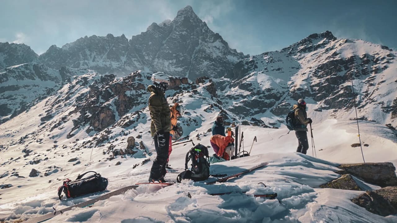 Groupe de skieurs en montagne, entourés de paysages enneigés et majestueux. Aventure alpine!