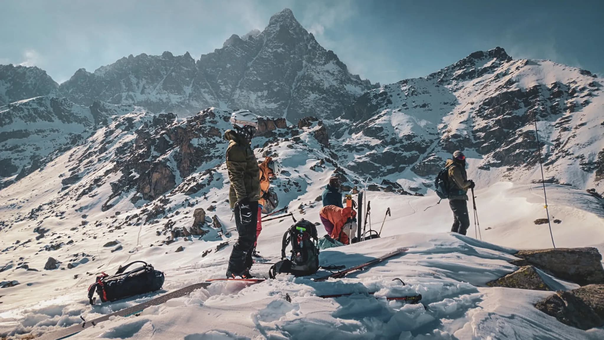 Groupe de skieurs en montagne, entourés de paysages enneigés et majestueux. Aventure alpine!