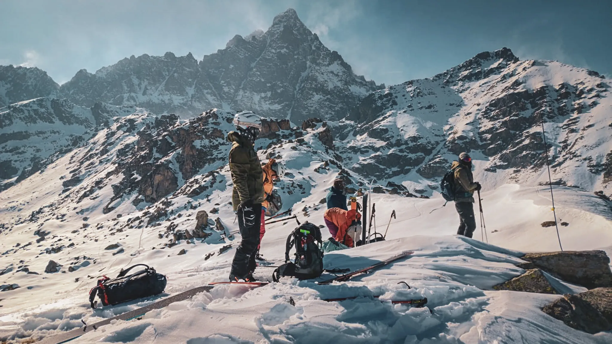Groupe de skieurs en montagne, entourés de paysages enneigés et majestueux. Aventure alpine!