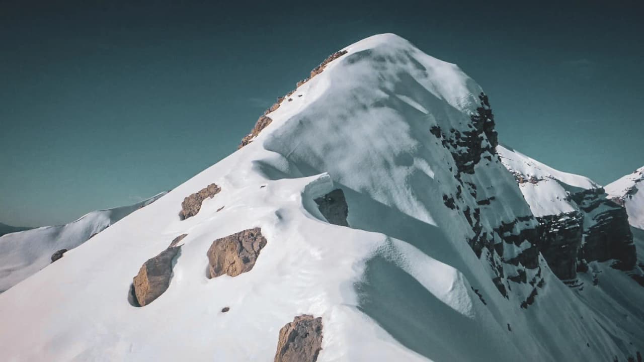 A snow-capped peak in the Écrins range beneath a clear blue sky – the perfect setting for a ski touring adventure.