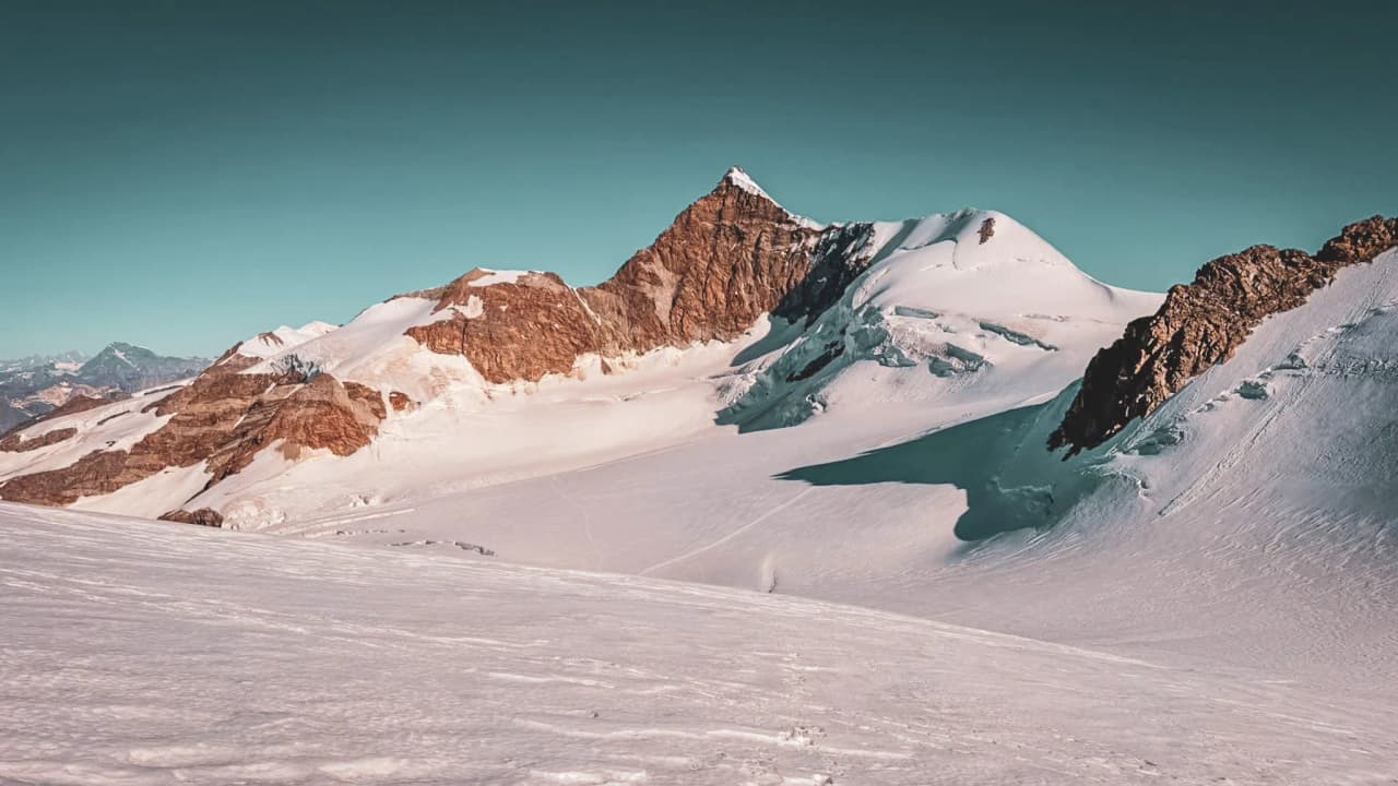 The breathtaking alpine landscape of Monte Rosa, with glaciers glistening beneath a clear blue sky – an invitation to adventure.