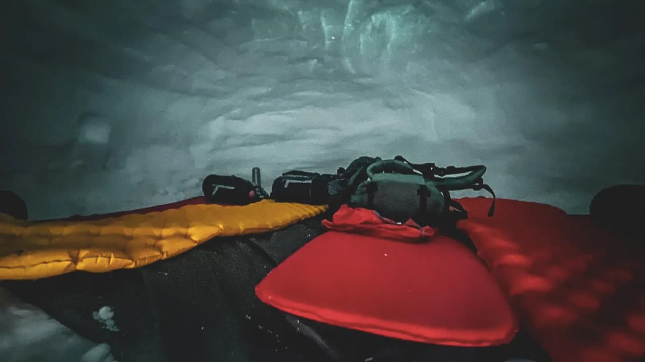Binnen in een gezellige iglo, met kleurrijke matrassen, klaar voor een nacht onder de sterren in de bergen.