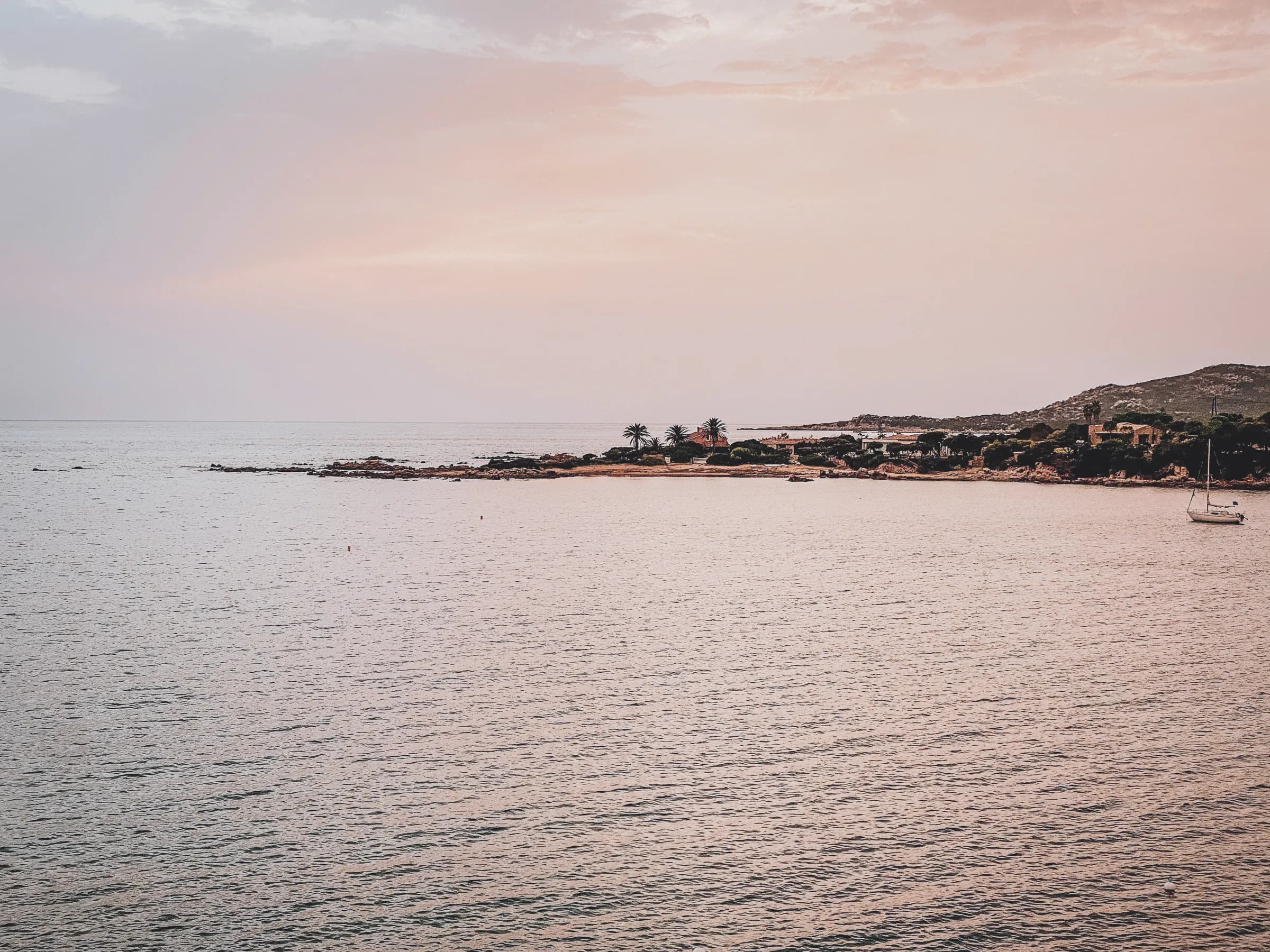 Coucher de soleil sur la mer, côte sauvage de Corse, une invitation à l'évasion nautique.