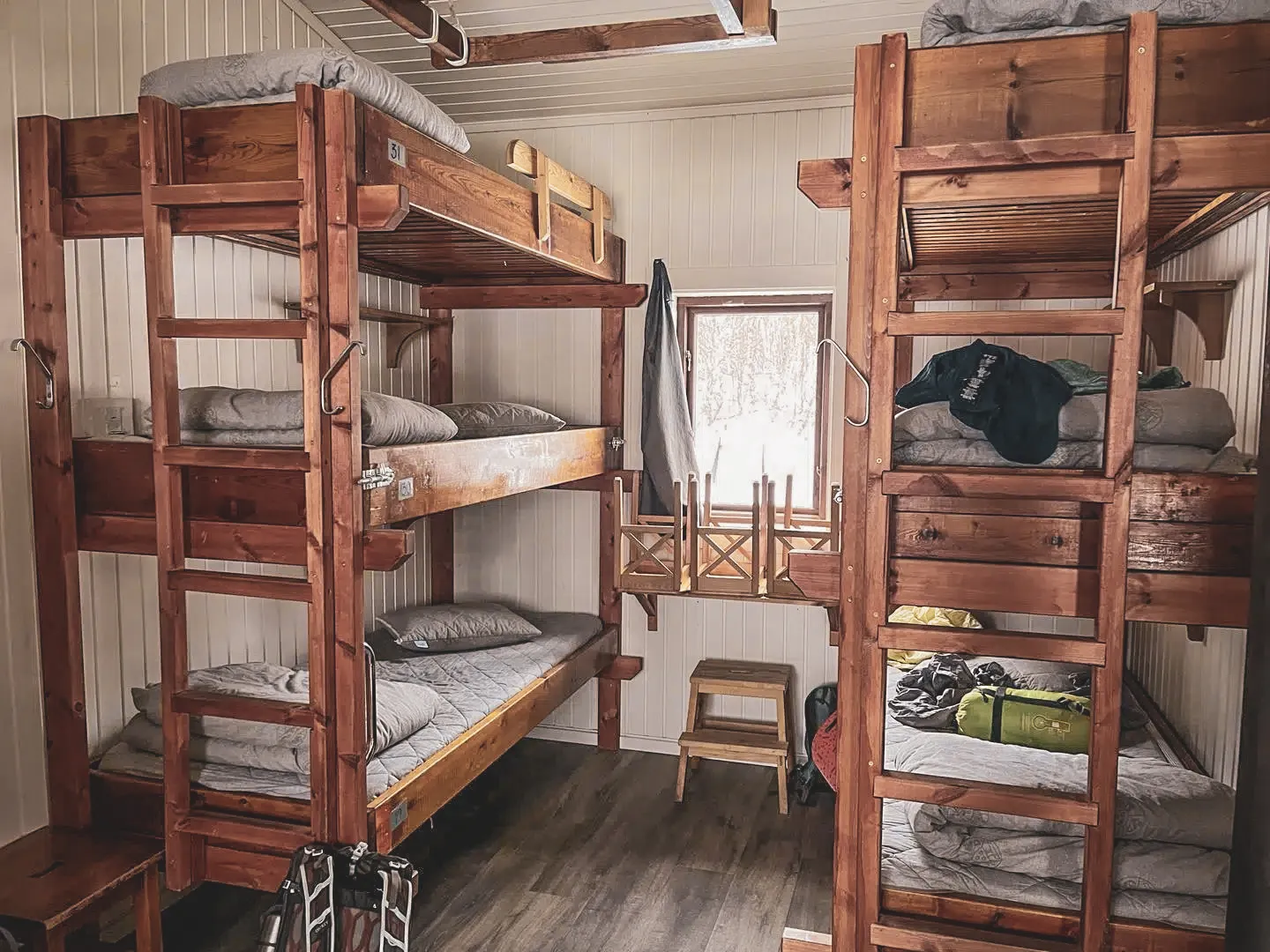 Chambres en bois chaleureuses avec lits superposés, invitant à l'aventure en Laponie suédoise.