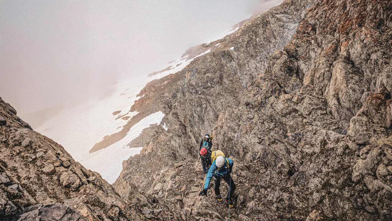 Alpinistes grimpant sur des rochers dans les Écrins, des sommets majestueux à explorer.