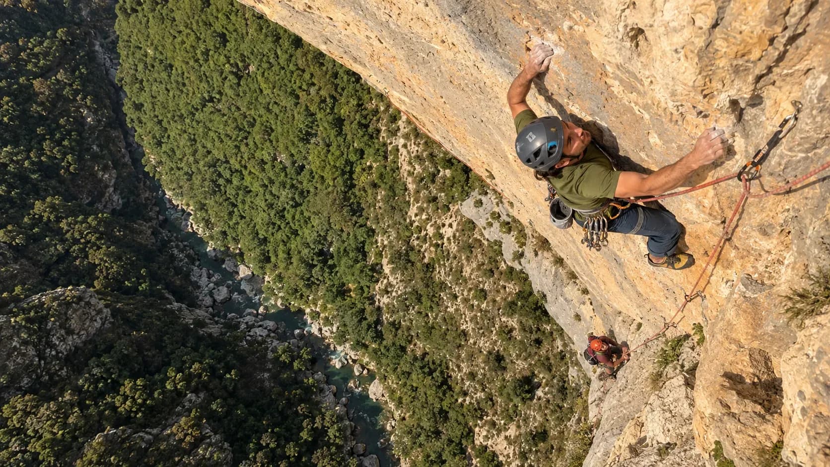 Escalade dans le Verdon : aventuriers sur une paroi rocheuse, panorama verdoyant et rivière en bas.