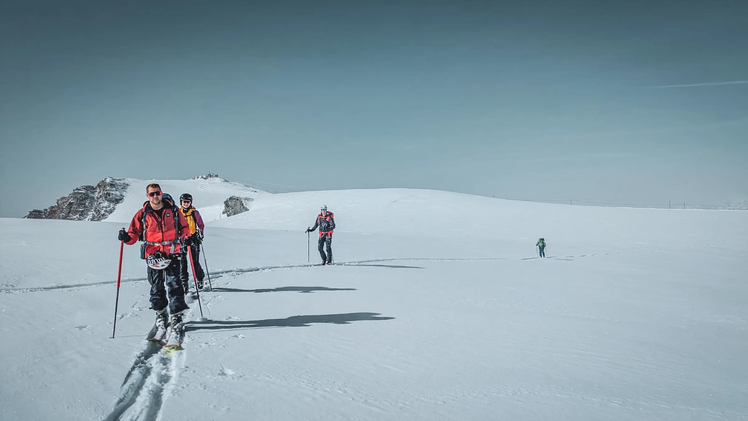 Groupe d'alpinistes en ski de randonnée, traversant un paysage glacé des 4000 du Mont Rose.