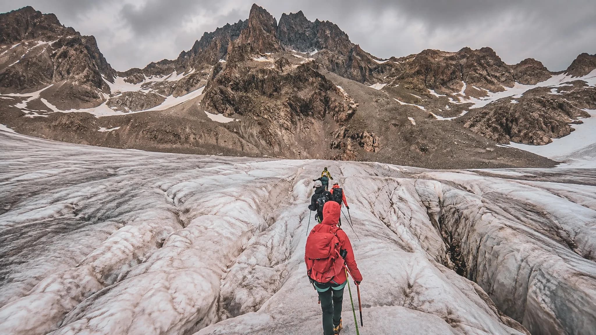 Un groupe de randonneurs explore un glacier enchanteur sous des sommets majestueux dans les Écrins.