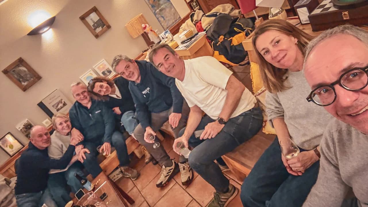 Groupe d'amis riant autour d'un verre, après une journée d'aventure en ski dans le Queyras.