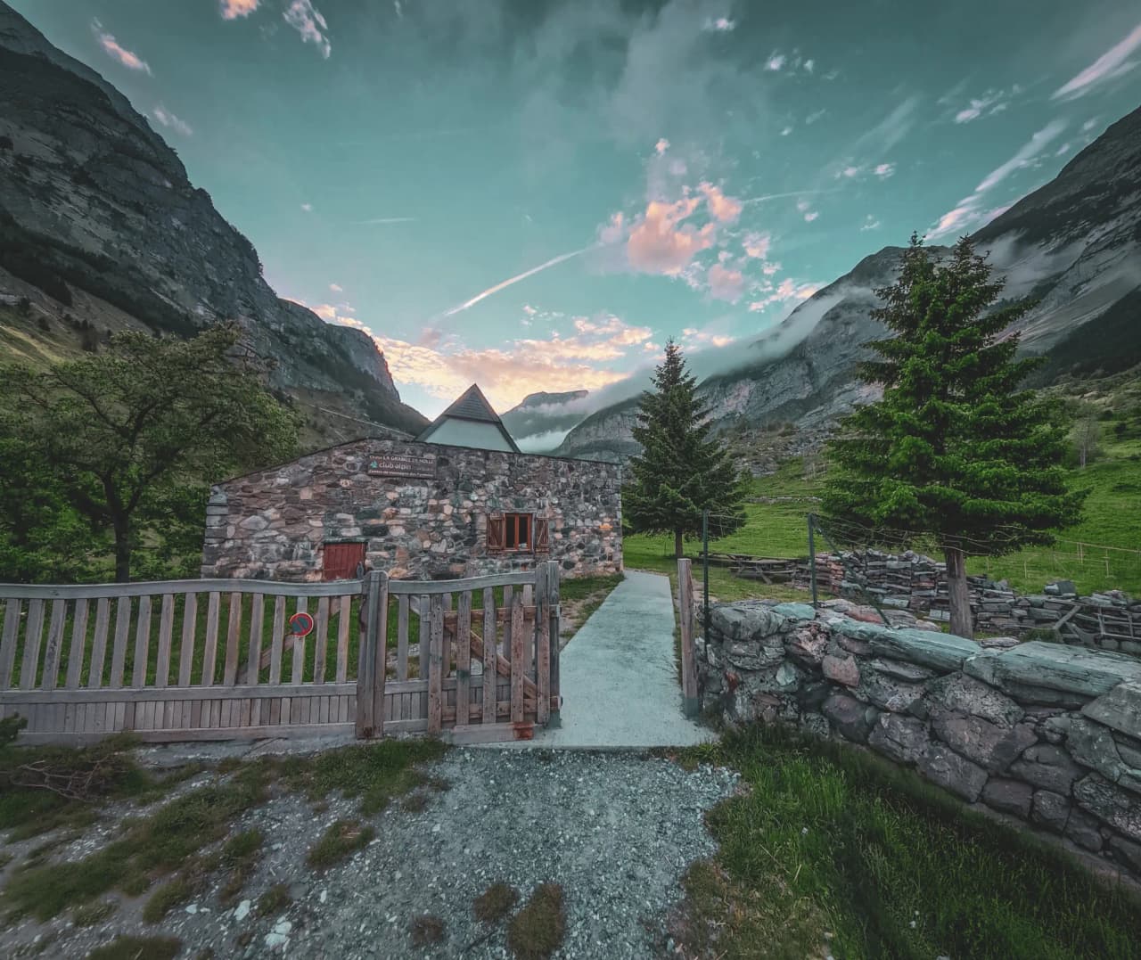 Refuge en pierre au lever du soleil, entouré de montagnes verdoyantes à Gavarnie.
