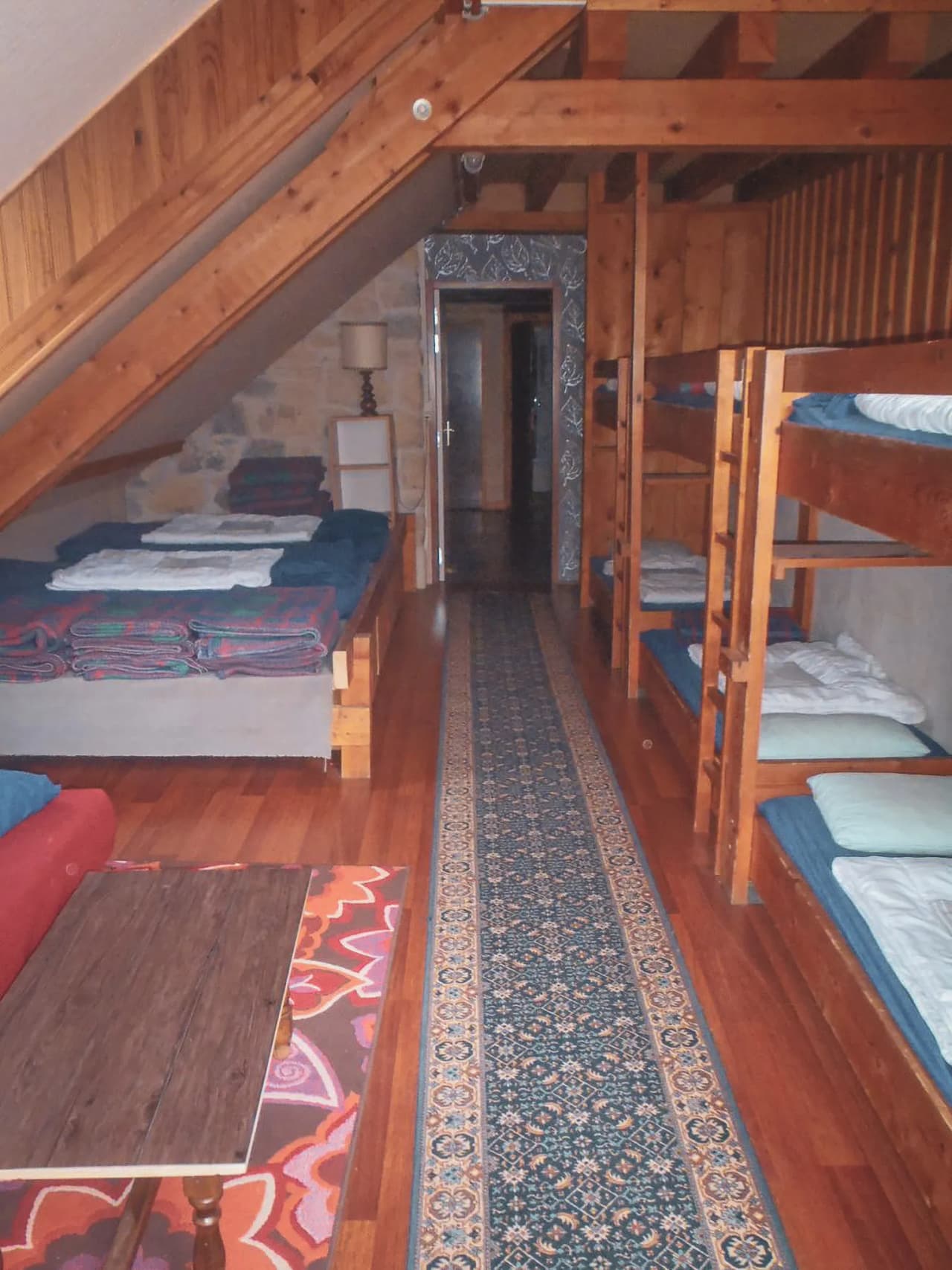 Auberge chaleureuse avec lits superposés et parquet en bois, idéale pour se reposer après une randonnée.