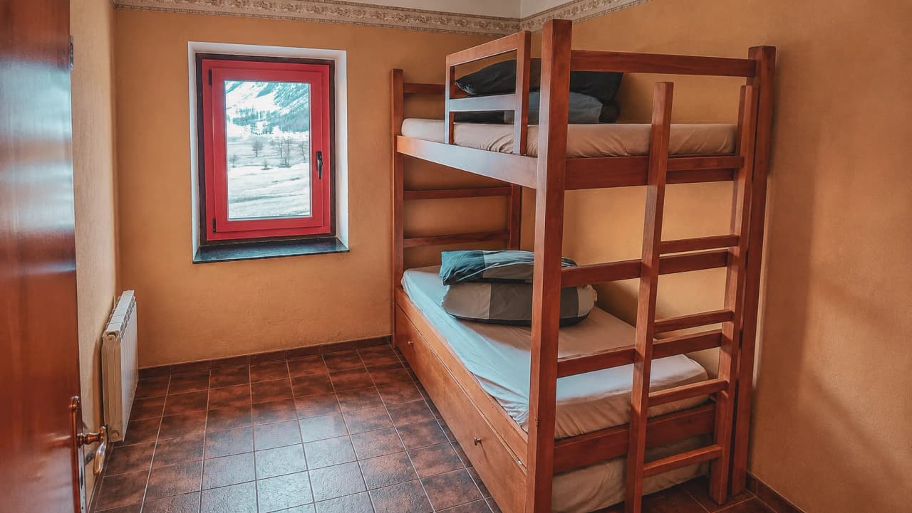 Comfortable room with bunk bed and mountain views, ideal for an adventurous break.