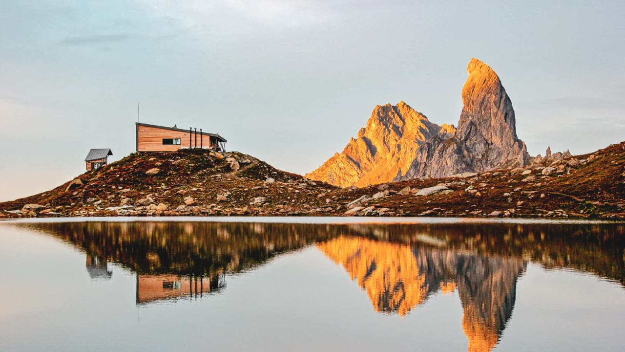 Reflet d'un sommet majestueux dans un lac calme, entouré de paysages spectaculaires.
