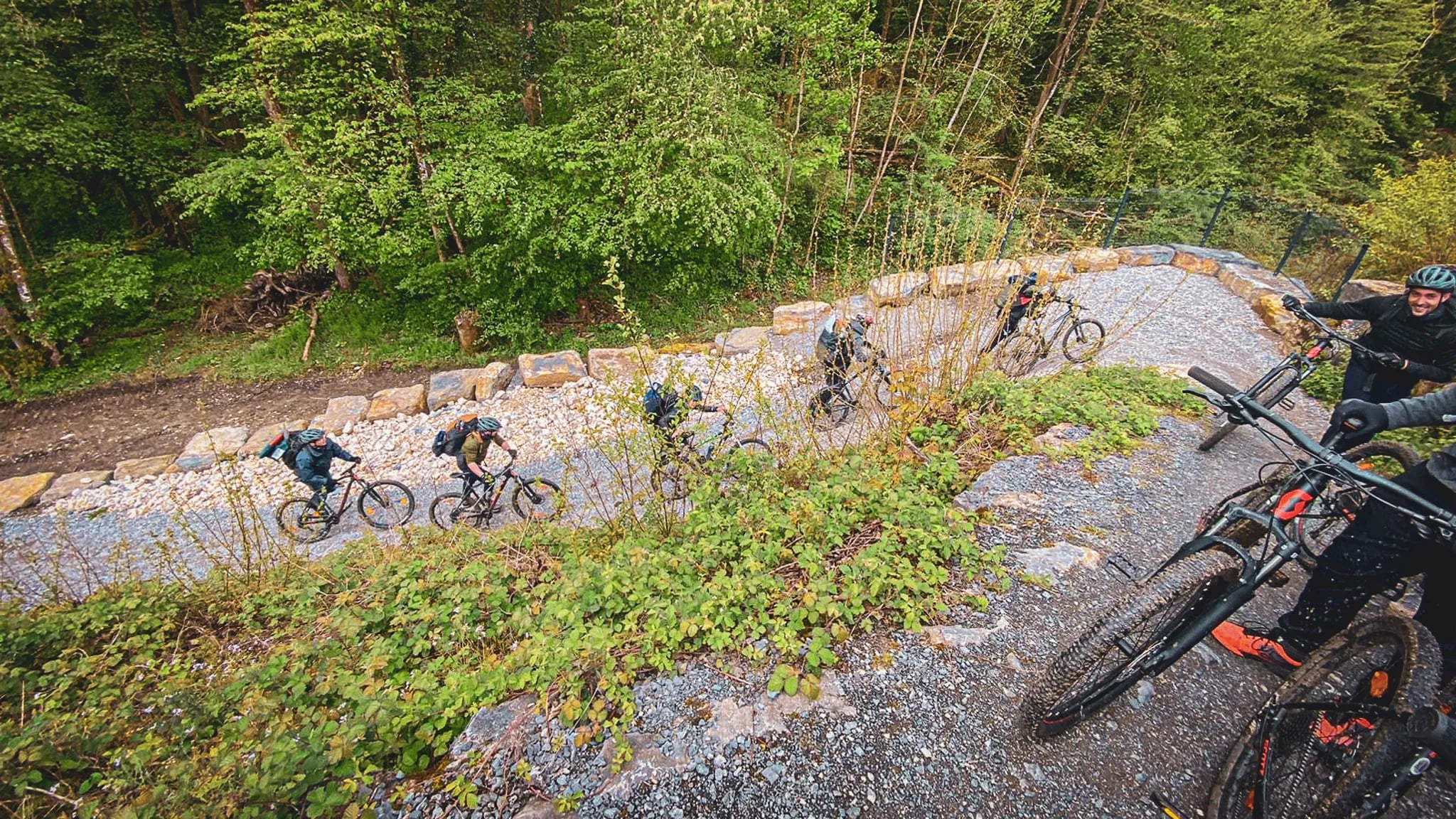 Des cyclistes grimpent un sentier entouré de verdure, prêts pour l'aventure en pleine nature.