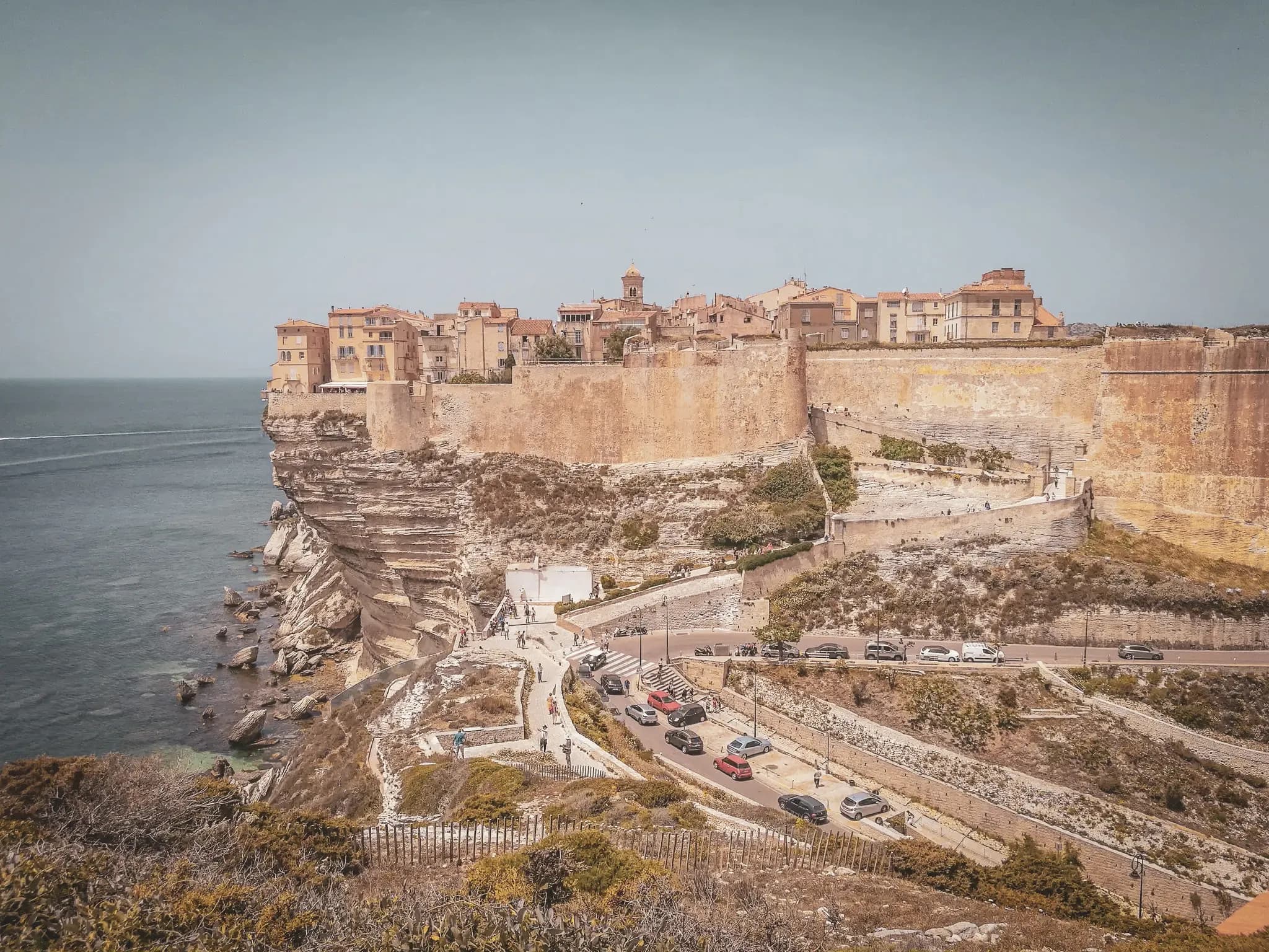 Vue panoramique de Bonifacio, bastion de calcaire surplombant la mer turquoise, invitation au voyage.