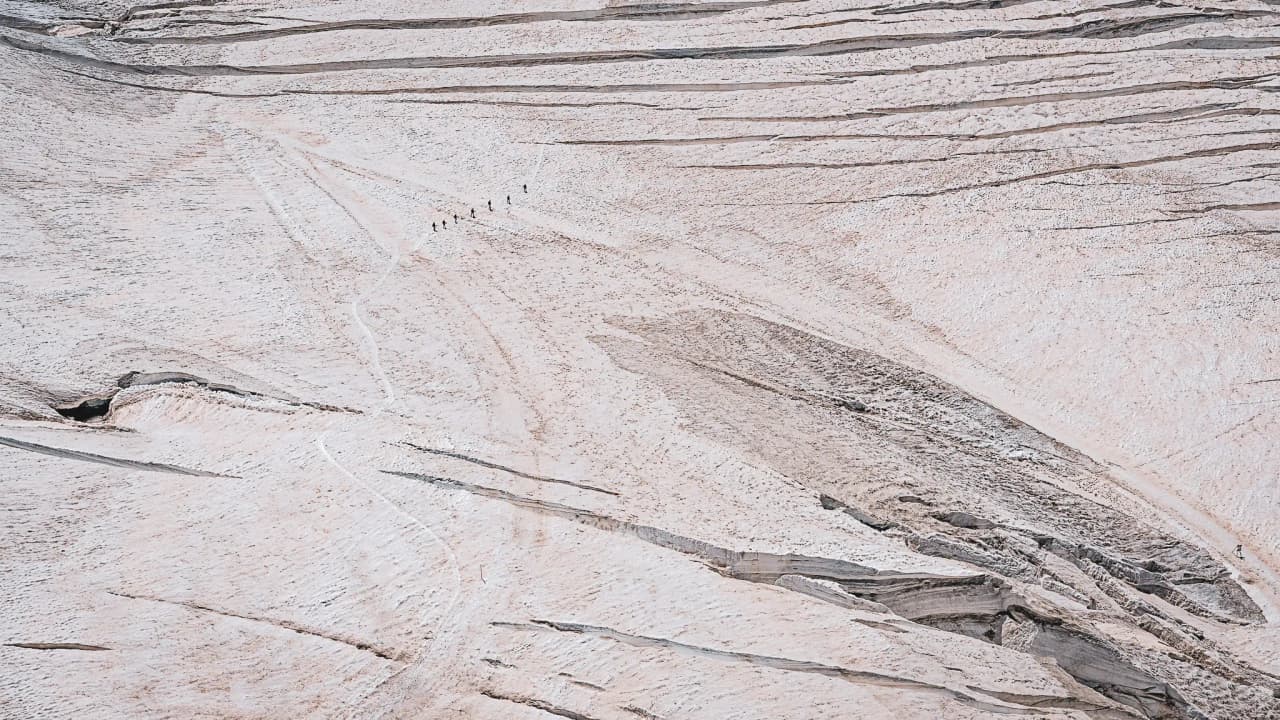 Randonneurs traversant le majestueux glacier d'Aletsch, face à des paysages alpins époustouflants.