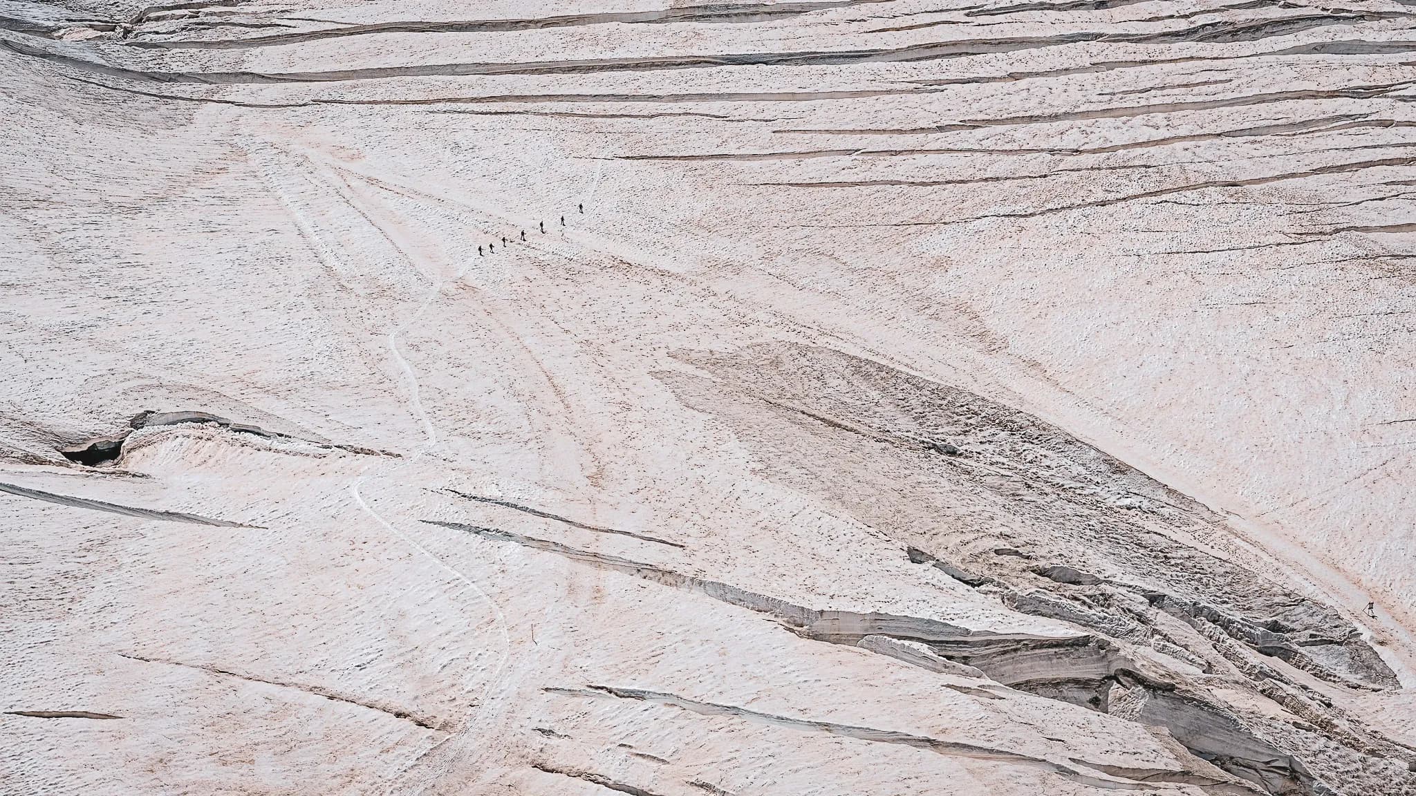 Randonneurs traversant le majestueux glacier d'Aletsch, face à des paysages alpins époustouflants.