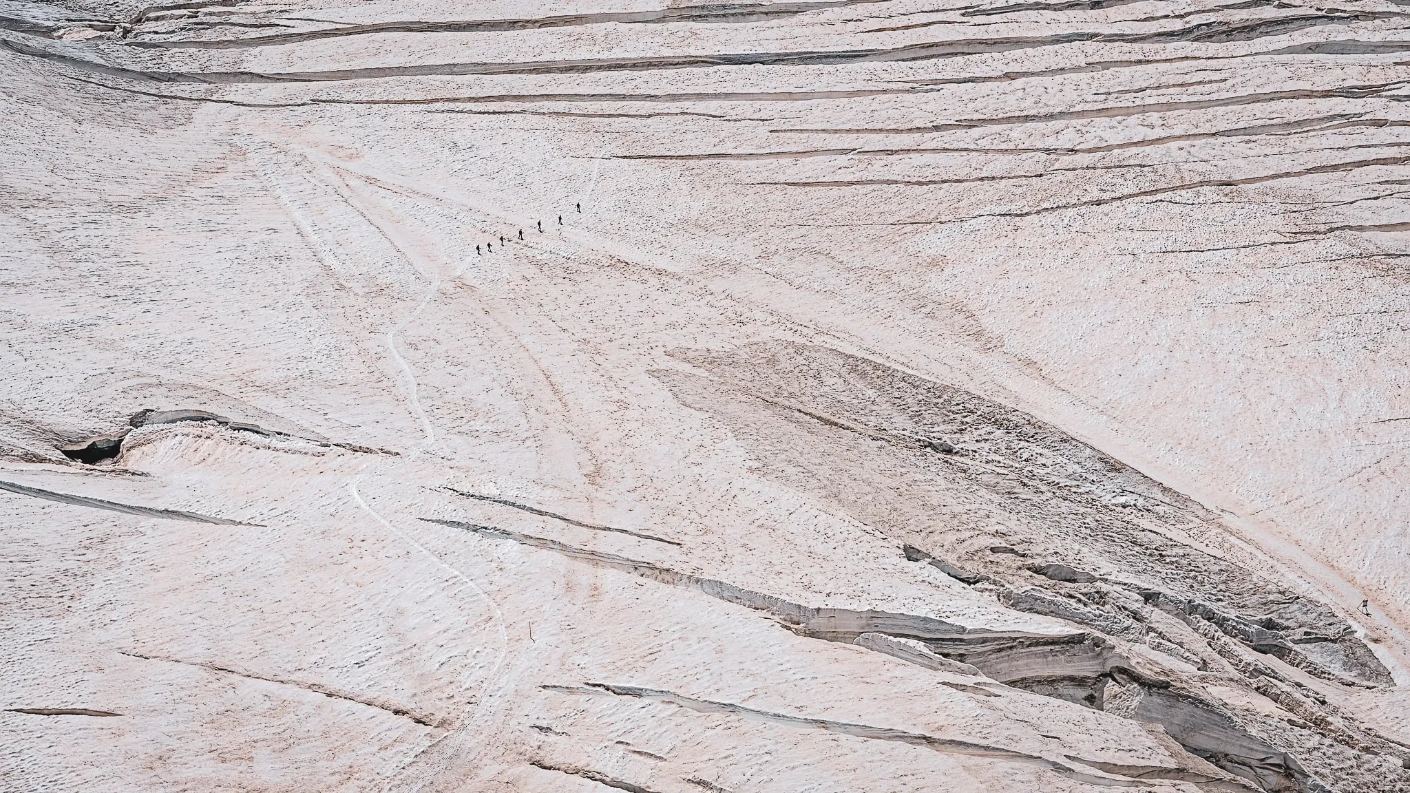 Randonneurs traversant le majestueux glacier d'Aletsch, face à des paysages alpins époustouflants.