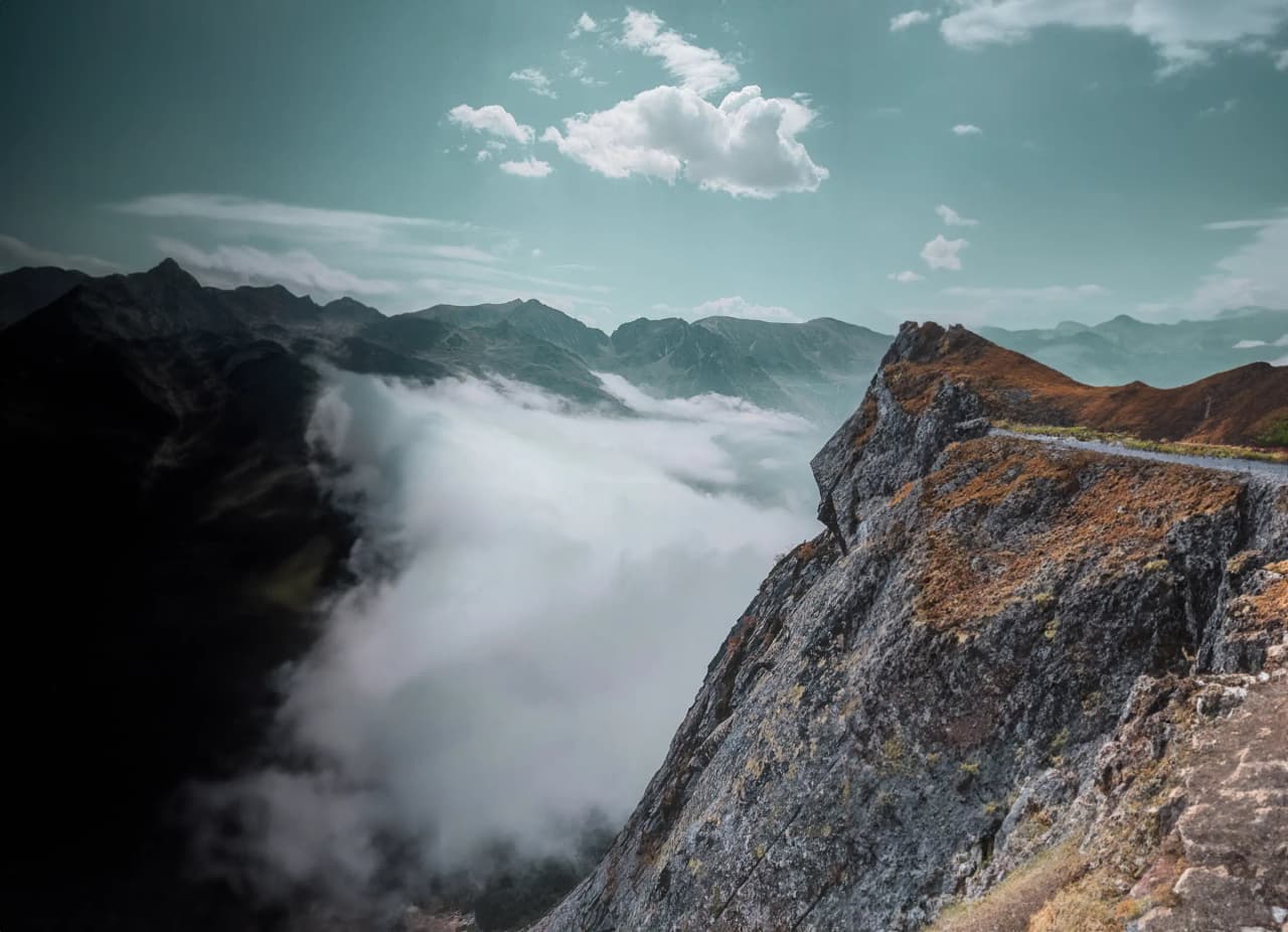 Vue panoramique des Pyrénées, nuages flottants au-dessus des montagnes majestueuses.