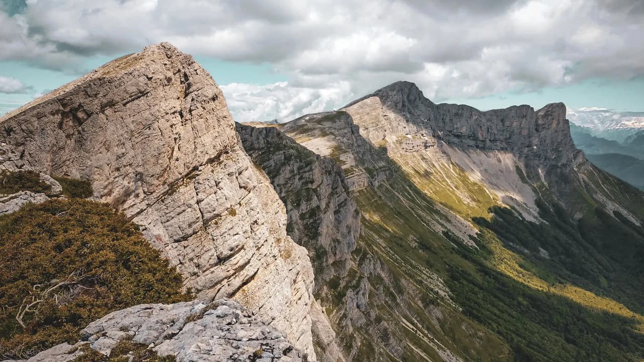 A majestic view of the Vercors, with impressive cliffs and scattered clouds.