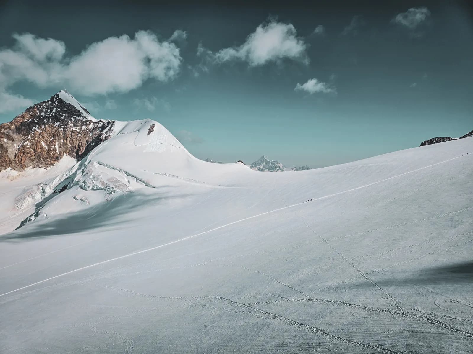 A breathtaking Alpine landscape of snow-capped peaks and blue skies, ideal for adventure.