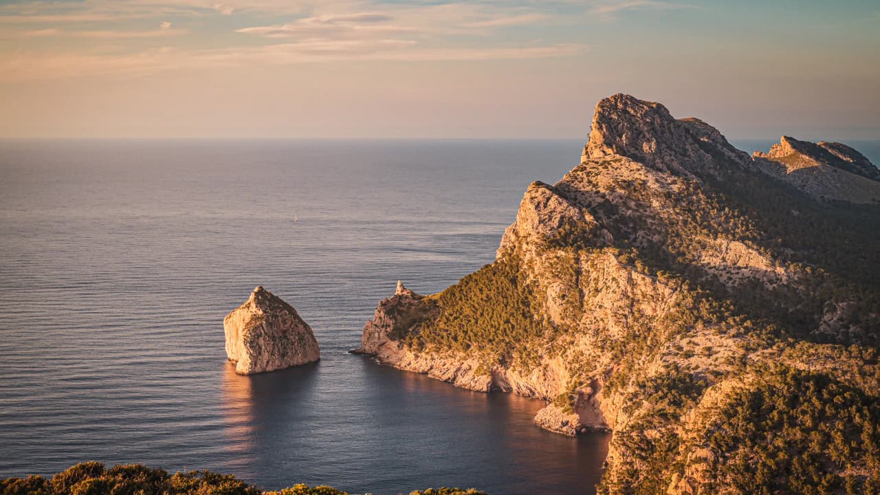 Sun-drenched coves in the Balearic Islands, calm seas, breathtaking mountainous landscapes.