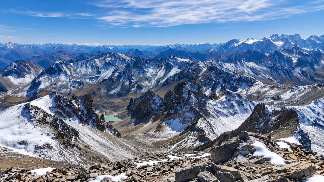 Panorama époustouflant des montagnes des Cerces, lacs turquoise et sommets enneigés.