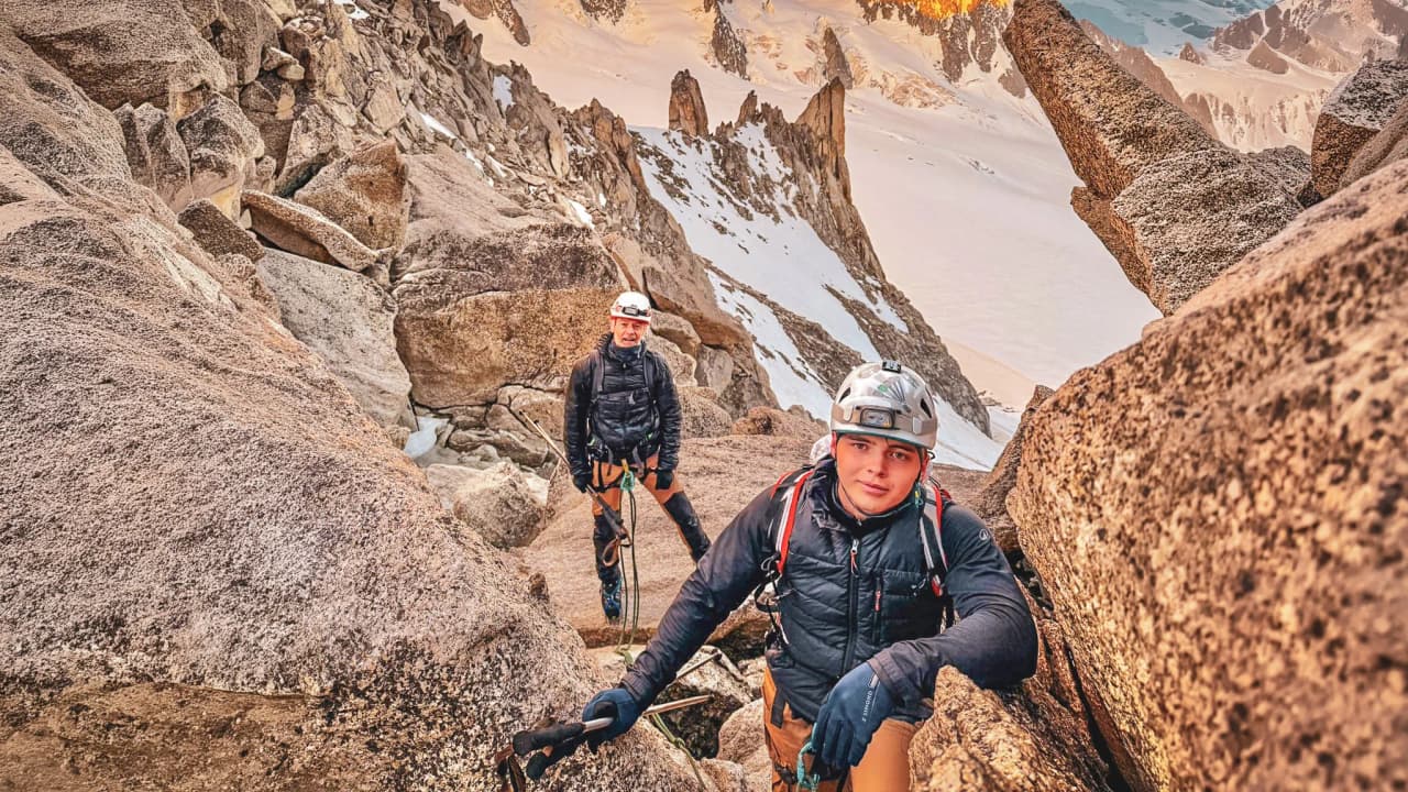 Three climbers lie on the snow, contemplating Mont Blanc and its majestic landscapes.