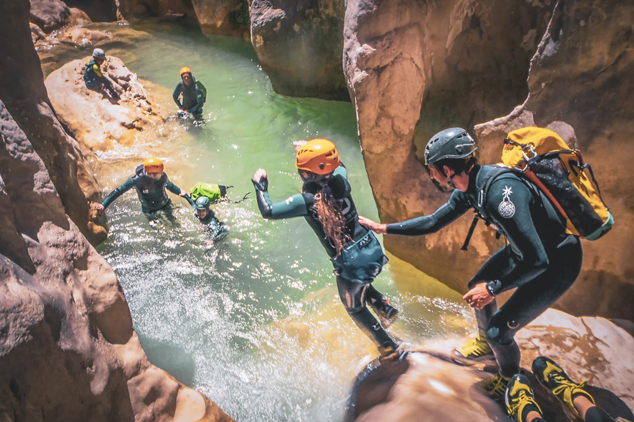 Canyoning team enjoying an aquatic adventure in the red gorges of the Sierra de Guara.