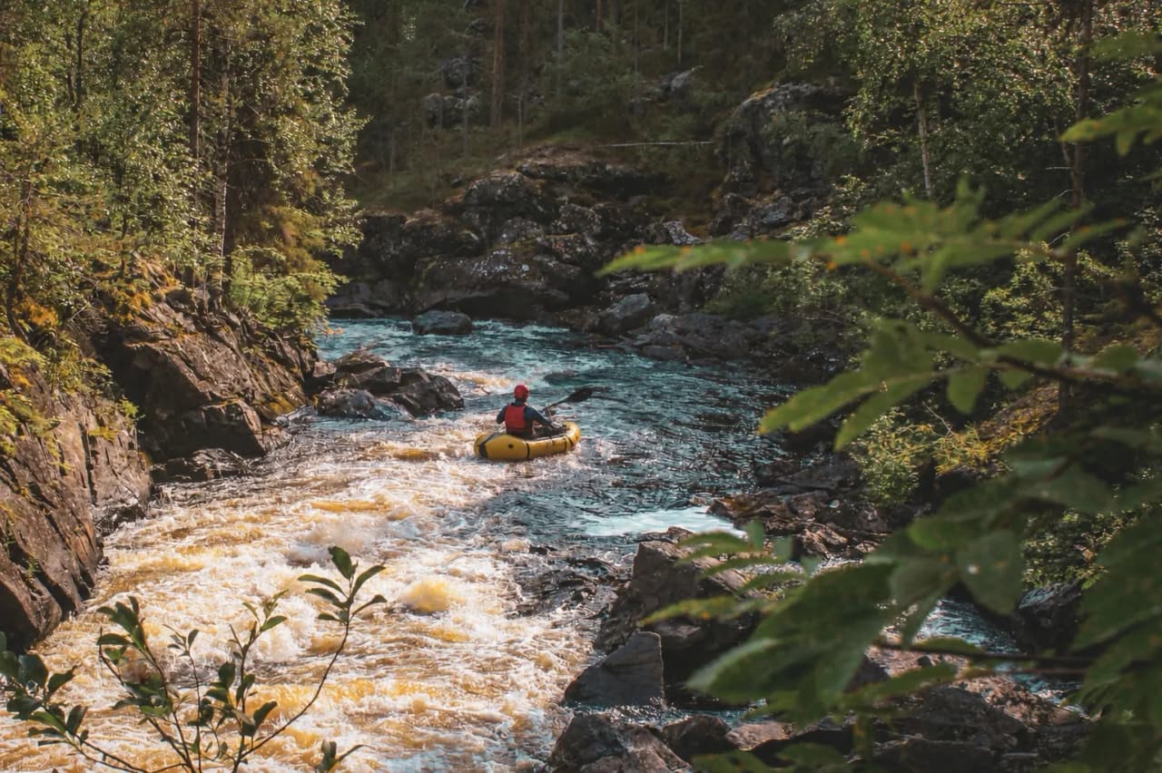 Rivière sauvage d'Oulanka, entourée de rochers et de verdure, invitation à l'aventure en Laponie.
