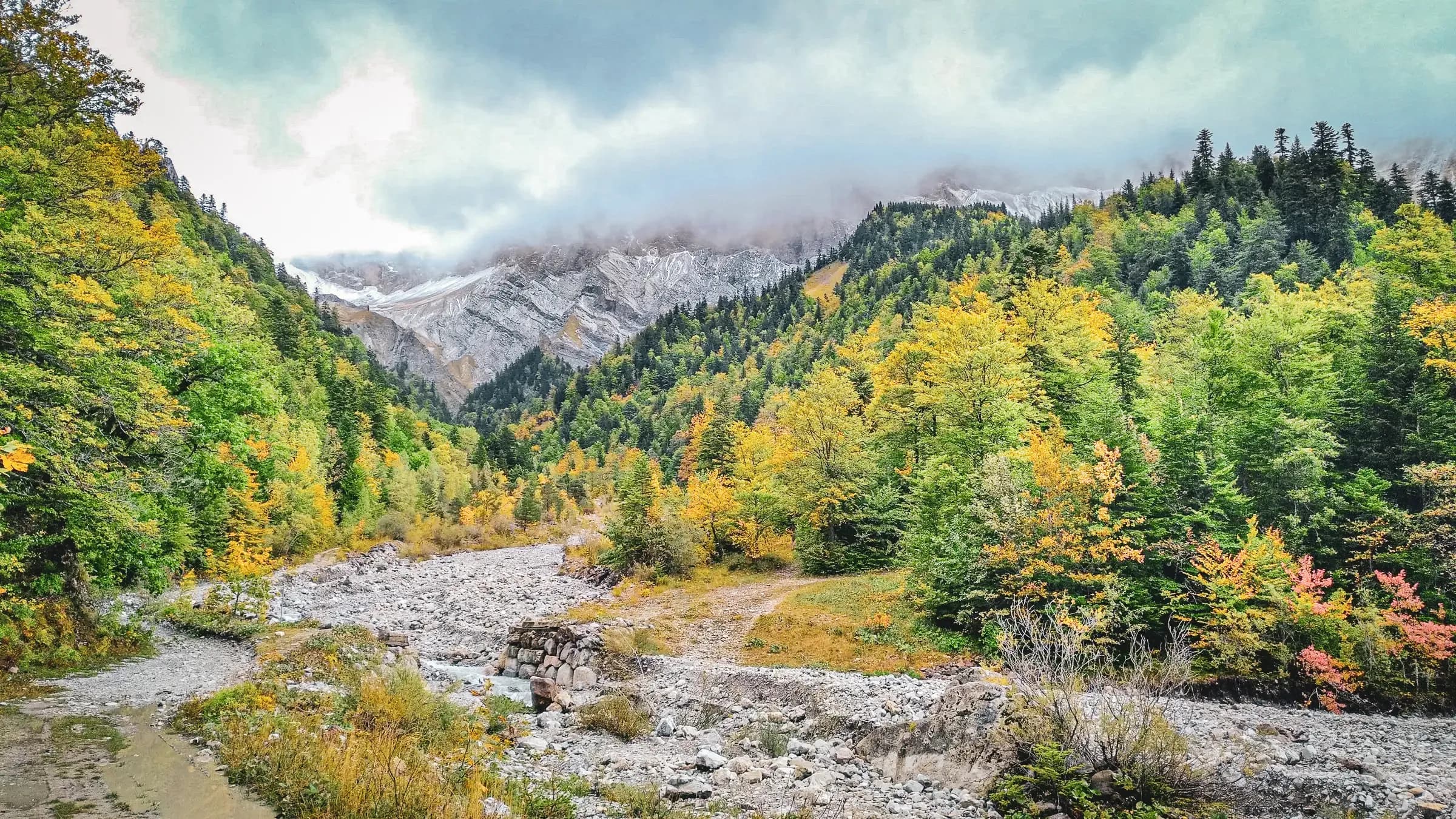 An enchanting mountain landscape, with autumn-coloured forests and majestic peaks.