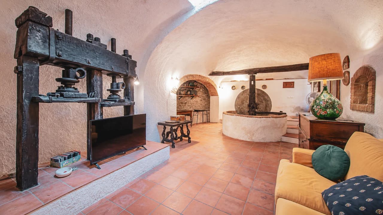 A cosy interior with stone walls, a comfortable sofa and rustic features, ideal for a relaxing stay in Finale Ligure.