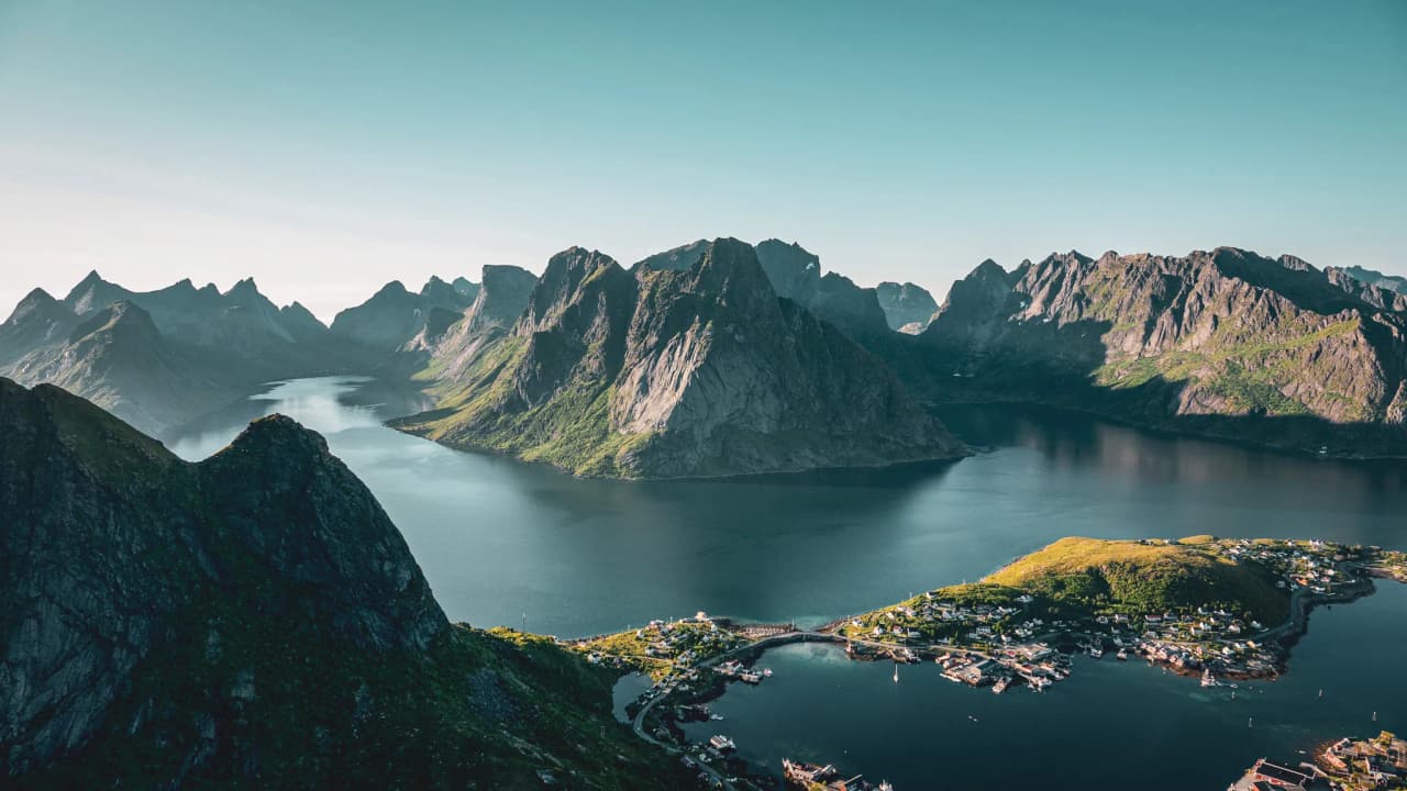 Majestic green mountains surround calm waters, a paradise for hikers.